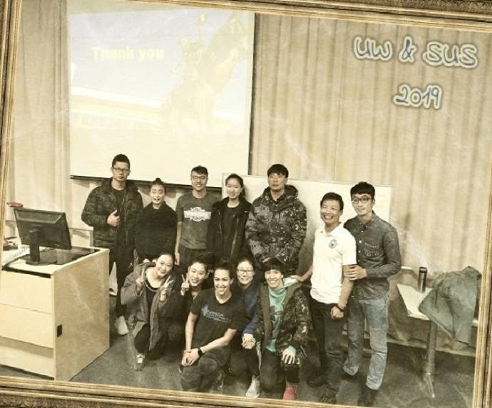 A sepia filter on an image of a group of people standing together and smiling at the camera.