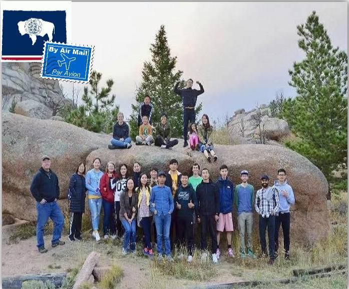 A group of people standing on a large rock.