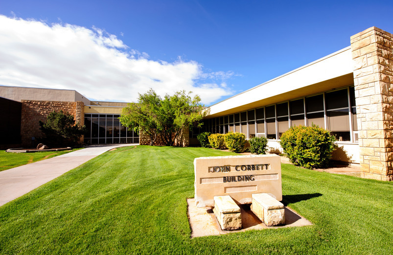 The exterior of a building with a stone sign that reads, "John Corbett Building".