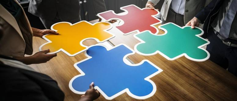 People working with a large puzzle. 