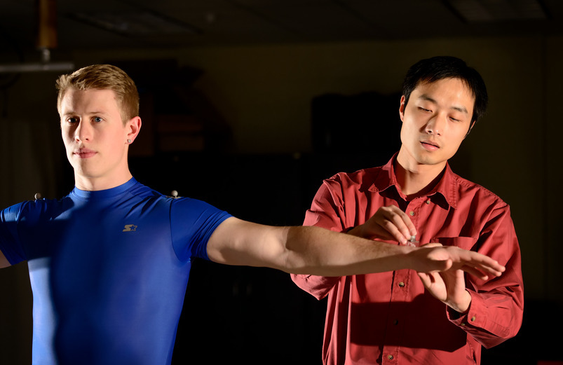 One person applies tracking nodes to another person.