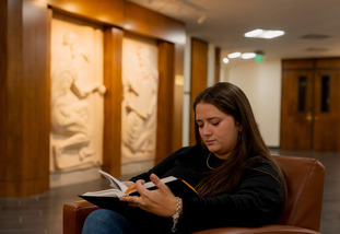 A student studies at her chair.