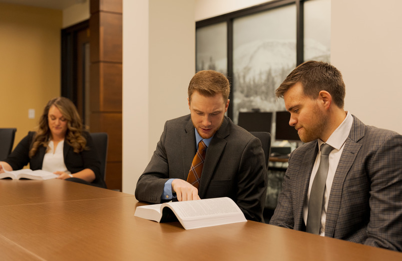 Two law students read from a text in a study space.