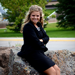Woman poses outside in business attire