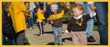 children walking wearing brown and gold