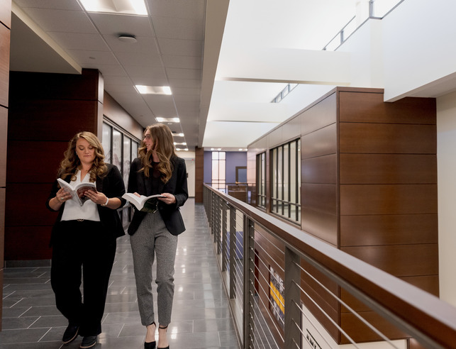A UW college of law admissions rep speaks with a student at her desk.