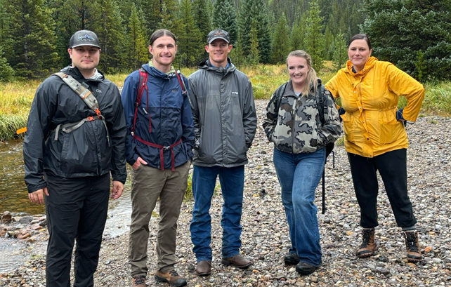 Professor Jason Robison and five UW Law School classmates near a stream