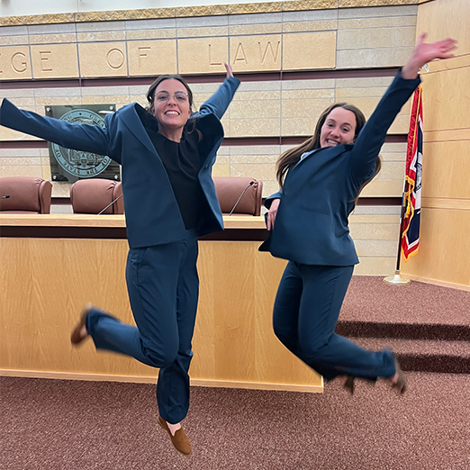 Smiling students in suits in courtroom