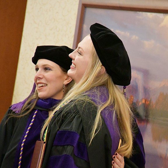student at graduation holding diploma cover