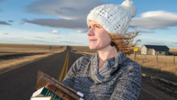 woman on rural road holding law books