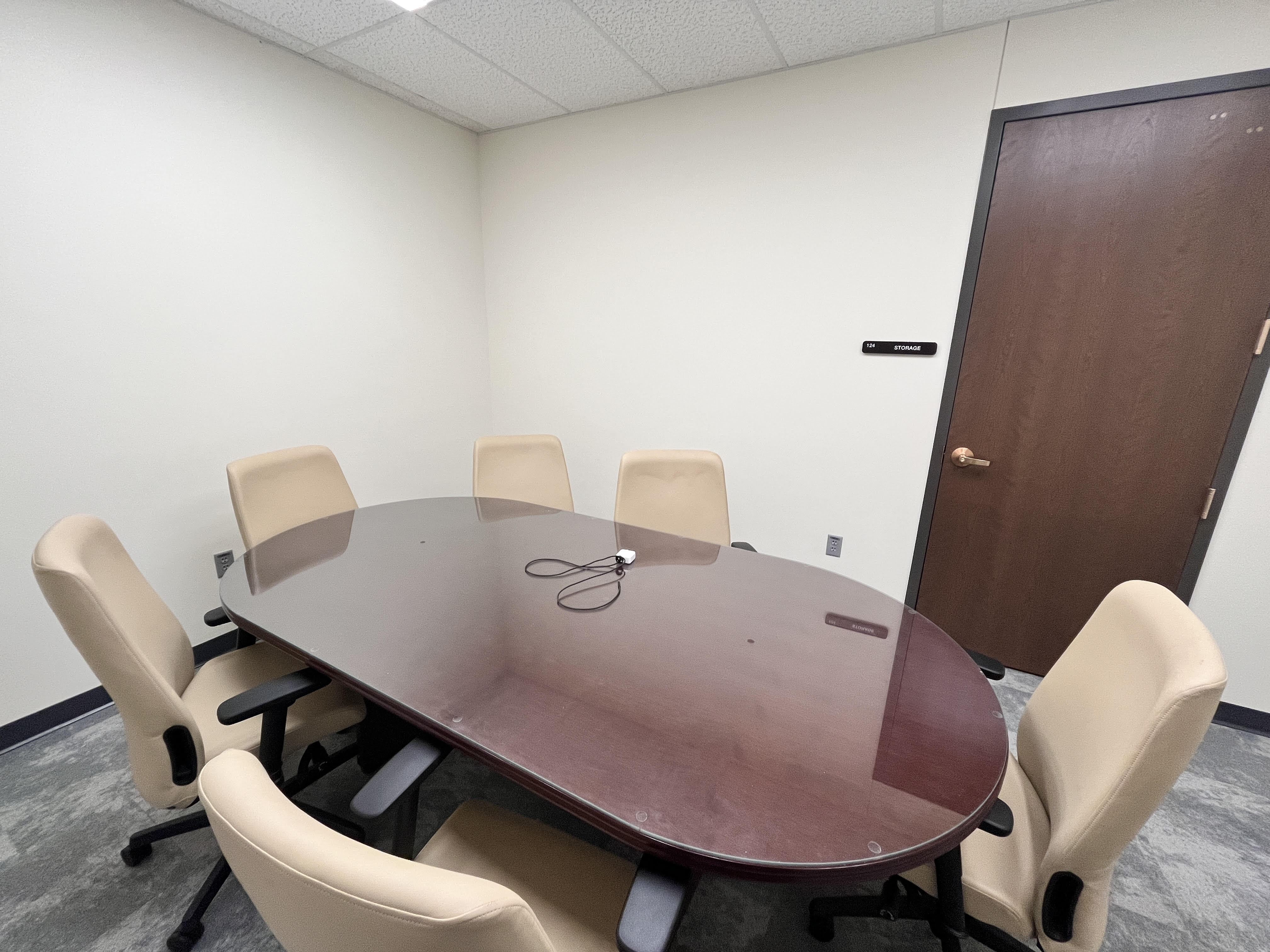 image of room 124, conatininga conference table and six tan office chairs