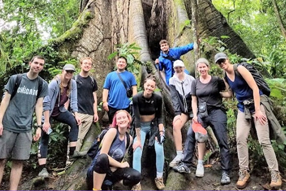 students and faculty from the FYE Abroad in January 2023 pose in front of an ancient Ceiba tree in Costa Rica