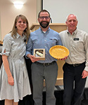 April Heaney and Richard Miller stand with Matt Gray (center) as he is presented a Pie Award