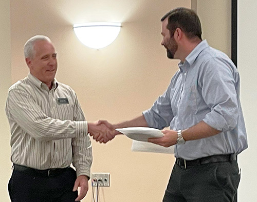 Richard Miller, Interim Director of ACES, presents John WIllford, WWAMI Medical Education Program Staff, with his 10th Pie Award.