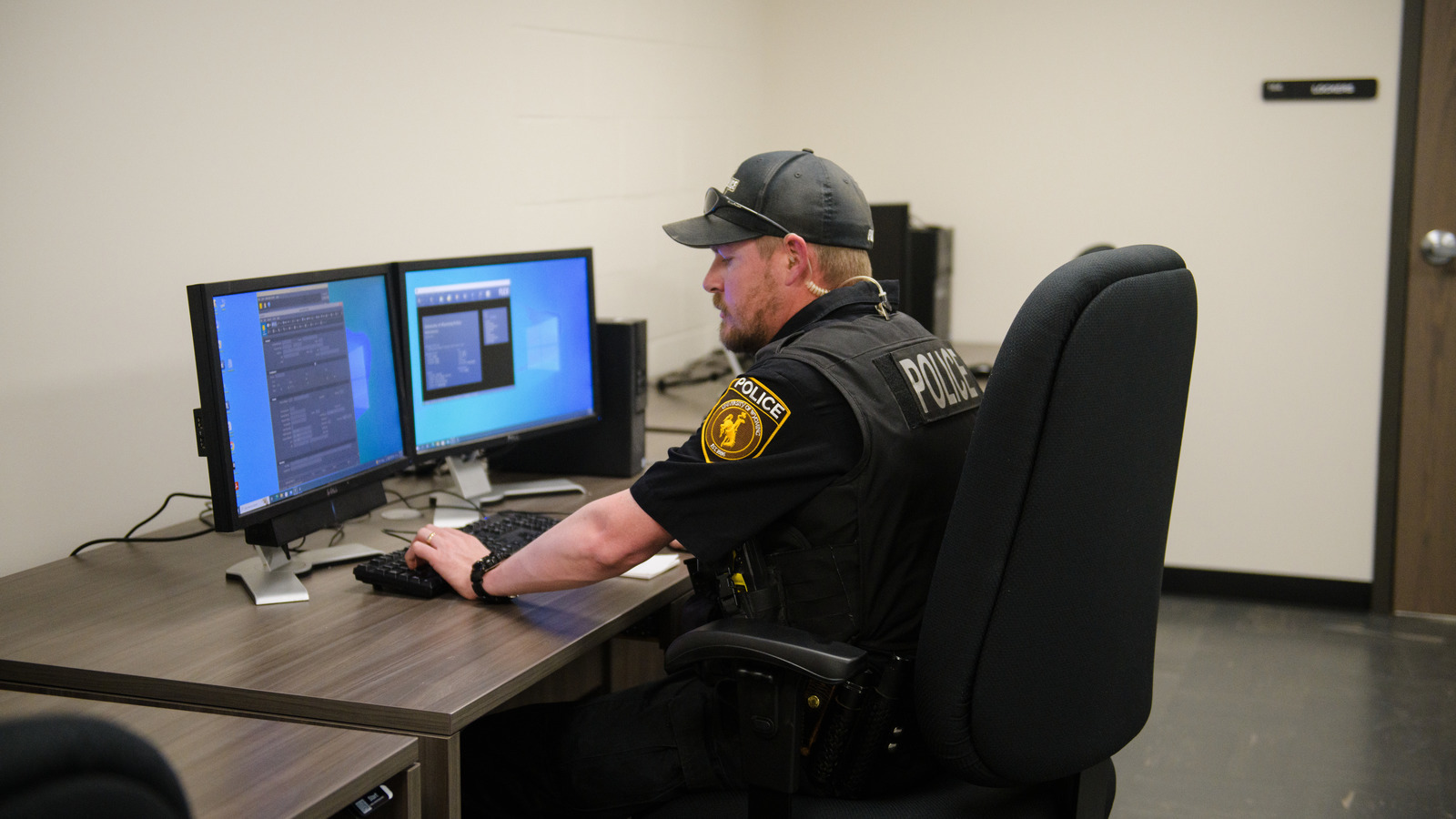 police officer monitors data on his computer