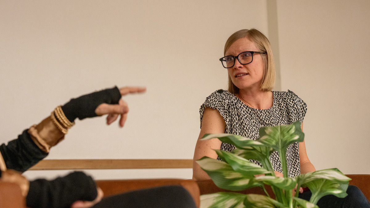 Catherine Johnson listens to understand as a speaker is gesturing with her hand.