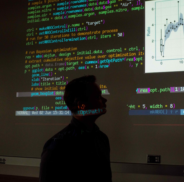 person looking at a projected screen of computer coding