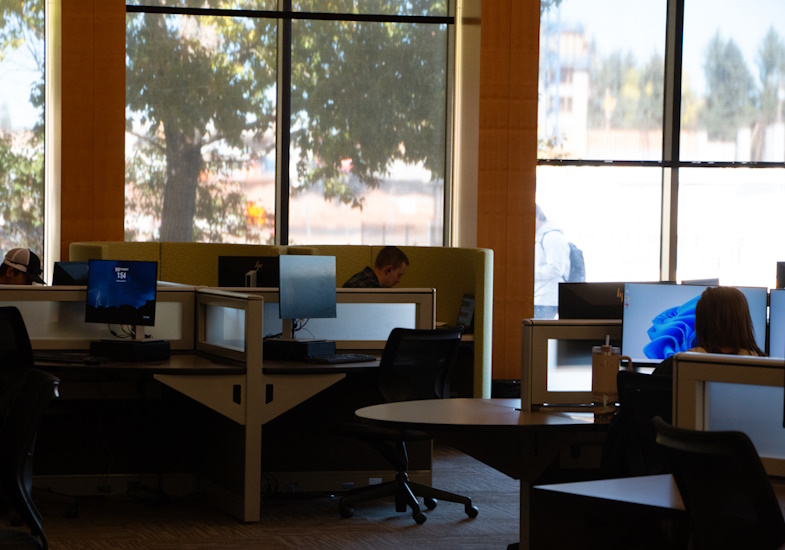 computer lab in Coe Library featuring desktop computers and students working at them.
