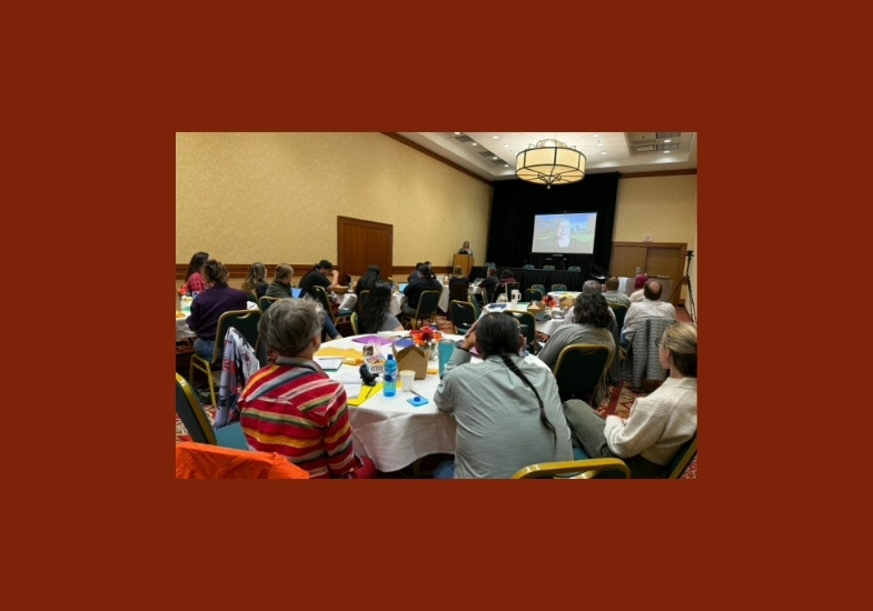  Applied Sovereignty: Dialogues in Indigenous Data sitting at round tables watching a keynote on a screen