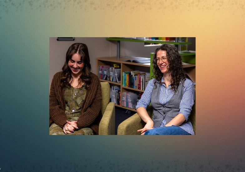 Ella and Janice sitting on a couch in the Honors Library