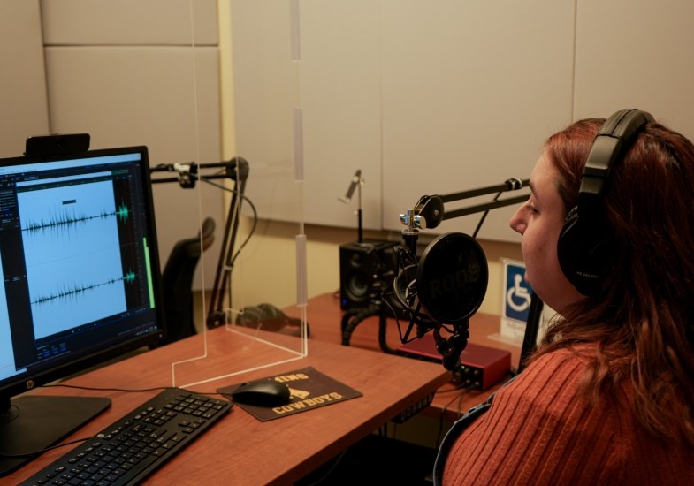 A student using the Studio Coe podcasting space.