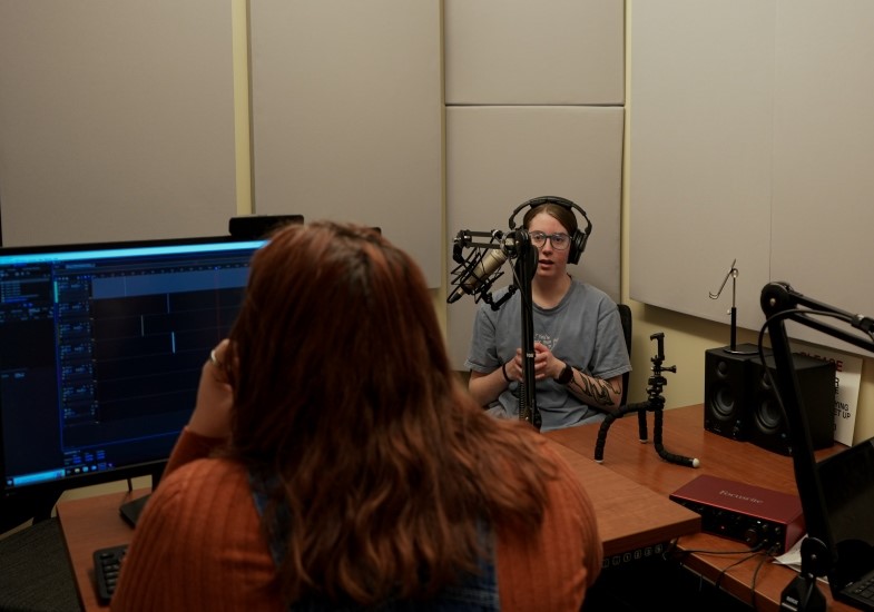 A student using the Studio Coe podcasting space.