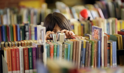 young person looking at books on a cart in the LRC 