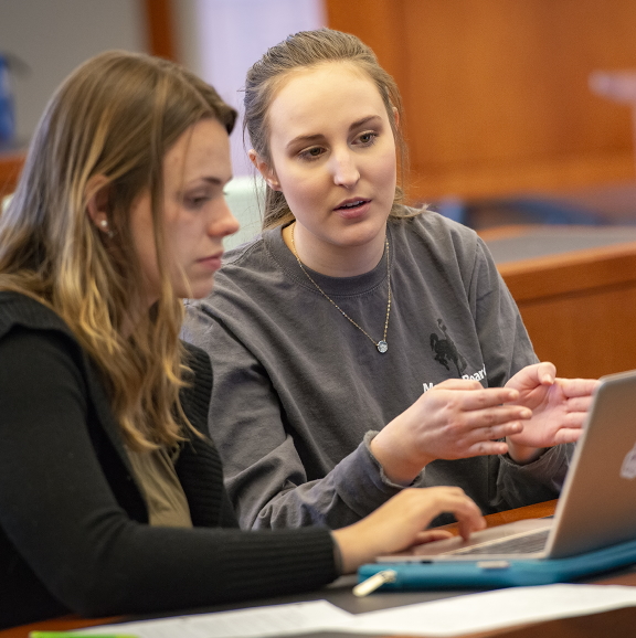 two people working on a laptop