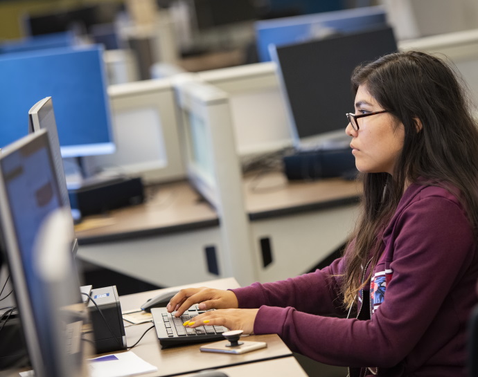 student working on a computer in the Coe Library computer lab