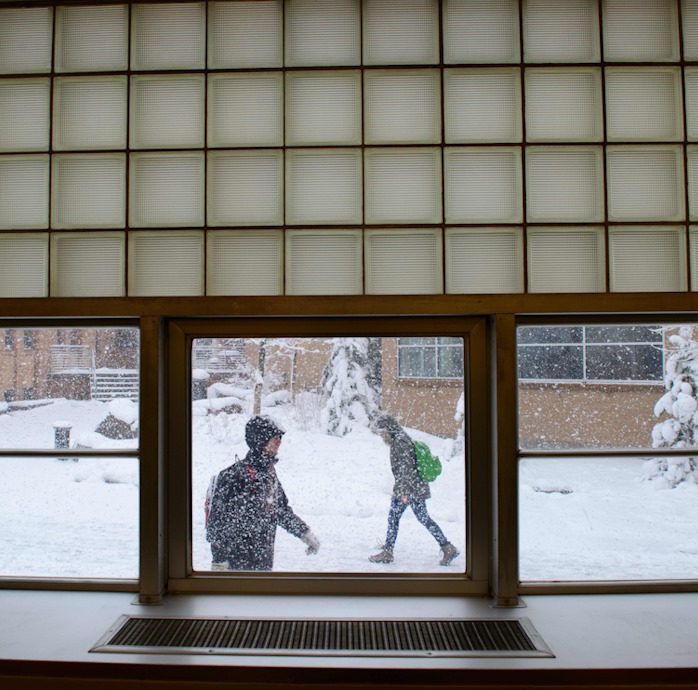 view of a snow storm from inside Coe Library