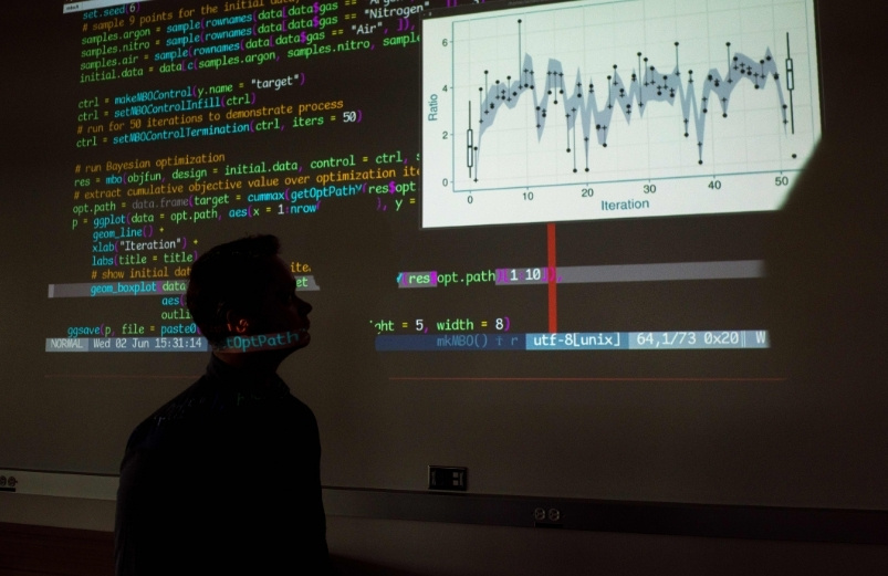 person reviewing computer coding on large screen