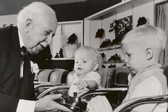 J.C. Penney with young children trying on shoes in 1958