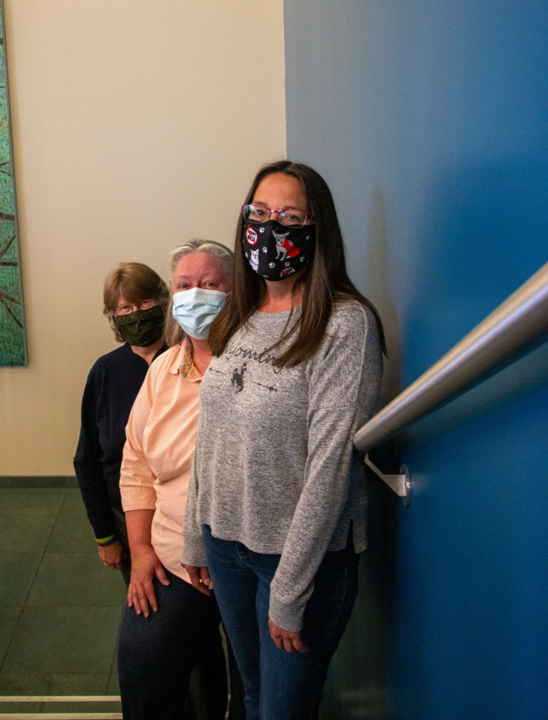 three UW library employees masked in the Coe Library stairwell