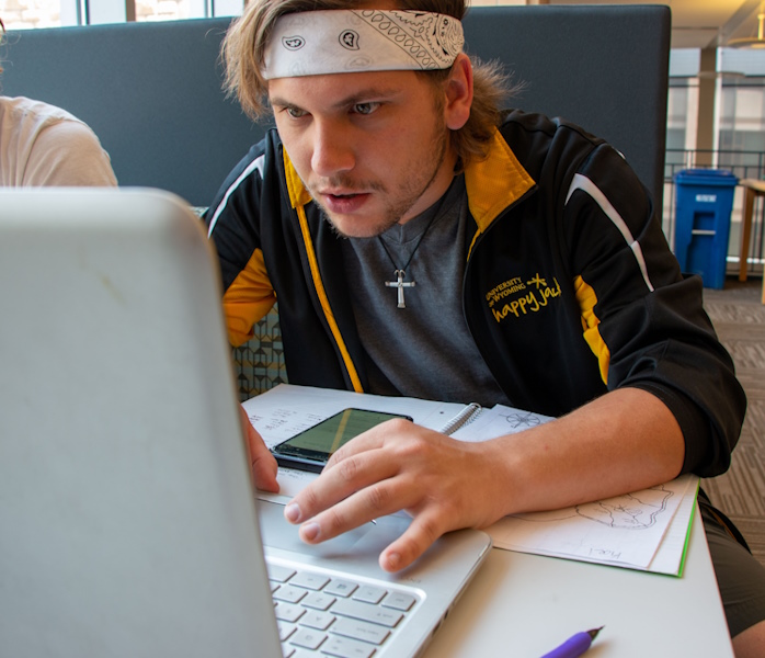 student working on a laptop in the computer lab in Coe Library