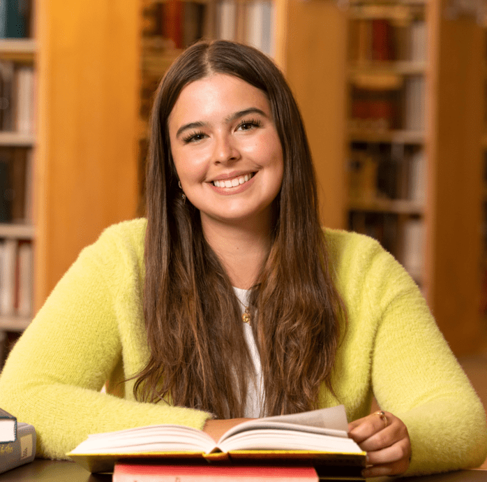 Student smiling while reading.