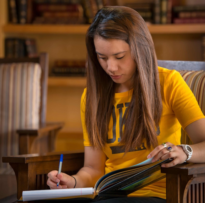 student reading a book in the McMurry room of Coe Library