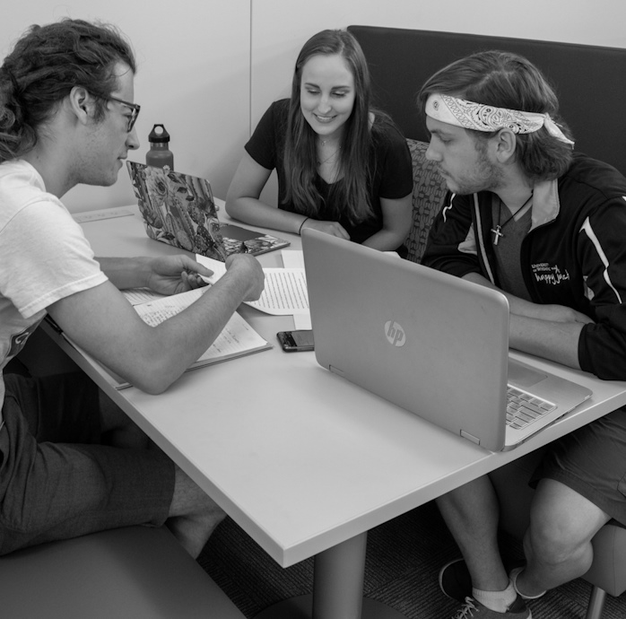 students working together on a project at a booth in Coe Library