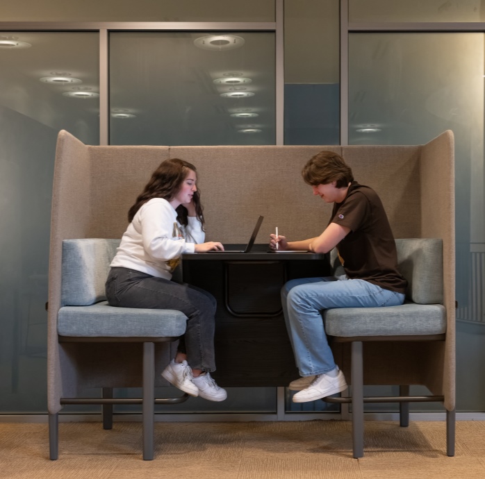 Two students sitting in a smaller study space.