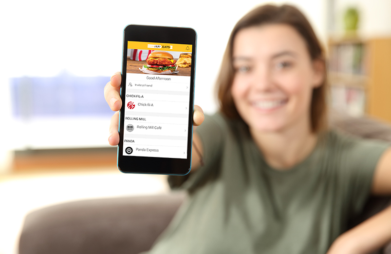 Person holding phone screen showing UwyoEats App