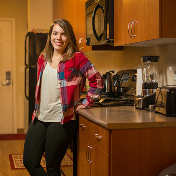 Student standing in a UW Apartment Kitchen