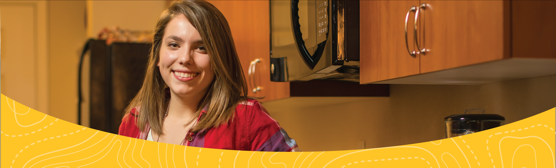 Female student standing in the kitchen of her Bison Run apartment