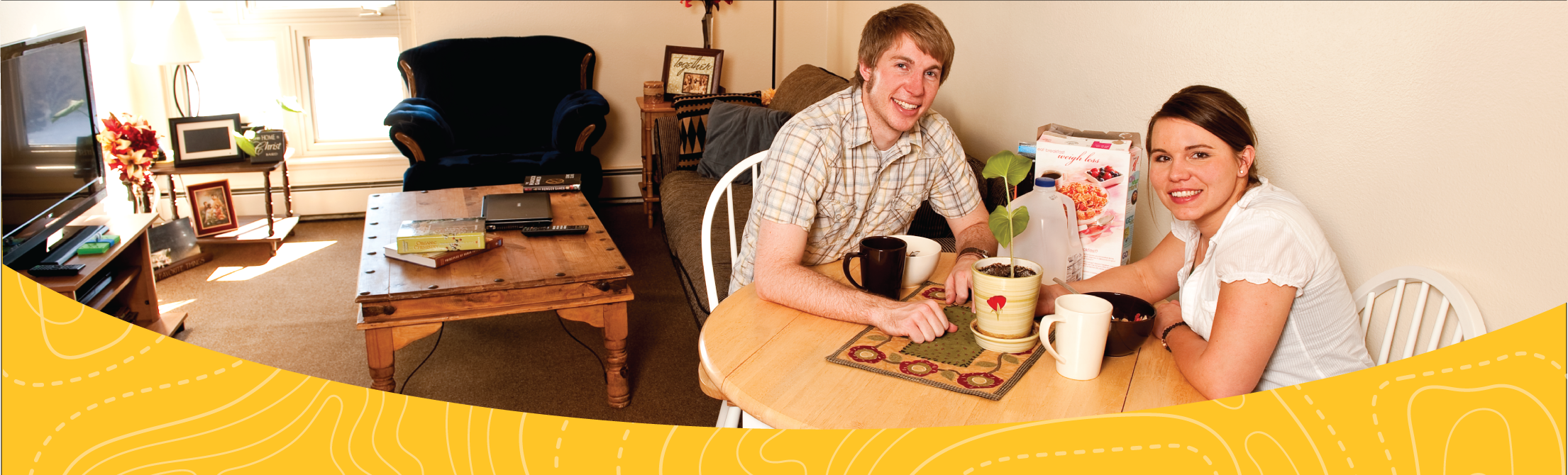 male and female student sitting at their dining room table in a spanish walk apartment