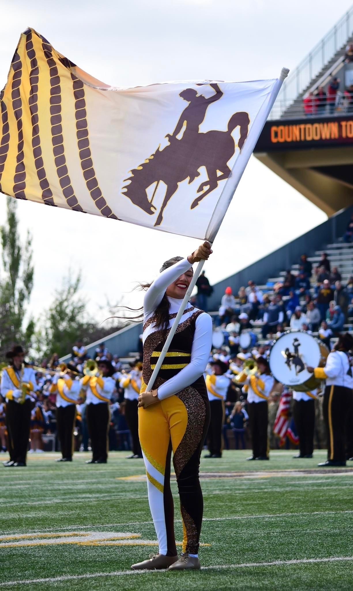Photo of color guard member smiling while holding flag with Steamboat Logo