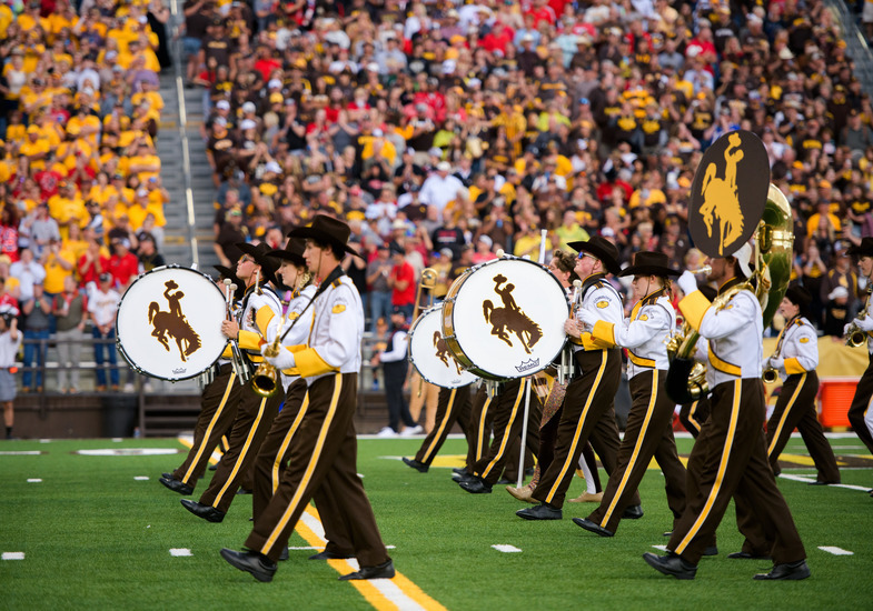 Drumline members of WTMB on field during game day, stepping off in straight lines.