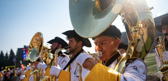 memebrs on the marching band play their instruments in a line
