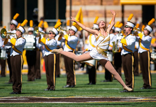 color gaurd memeber leaps in front of band members