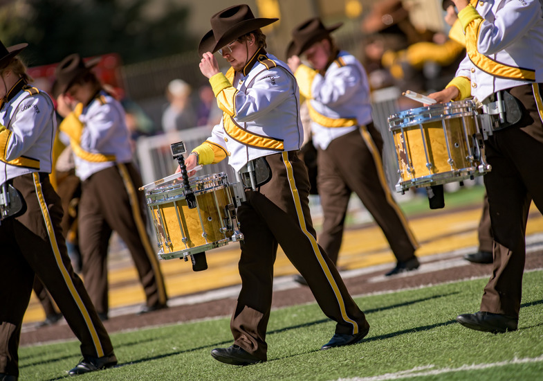Group of marching band members carrying drums