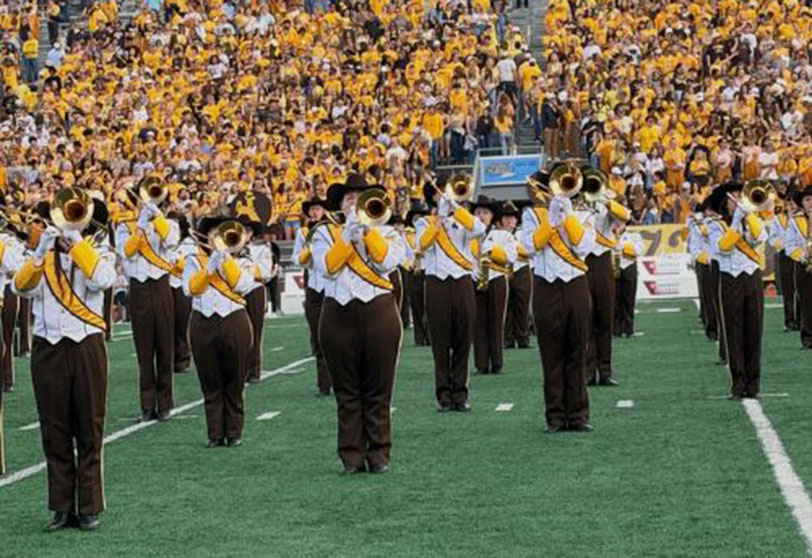 Marching band on field wearing cowboy hats