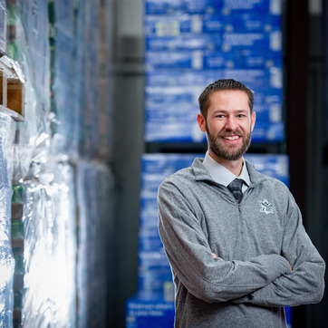 College of Business alumni standing in a beverage warehouse