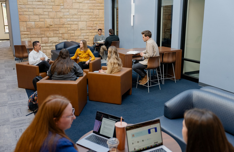 College of Law faculty and students sitting in the new spaces of the College of Law speaking with each other